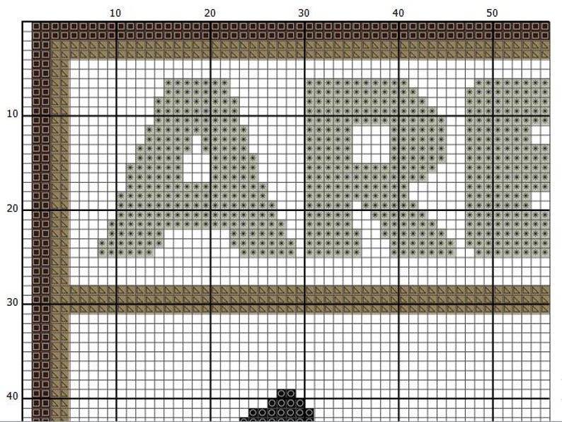 May include: A cross-stitch pattern on a white grid background featuring the letters A, R, and E in a light gray color. The design is enclosed by a dark brown border and a lighter tan inner border, with a small black shape visible at the bottom.