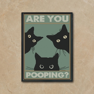 Puede incluir: Un bordado de punto de cruz enmarcado con tres gatos negros con ojos amarillos sobre un fondo verde azulado. El texto "ARE YOU" está en la parte superior y "POOPING?" en la inferior. El marco es negro.
