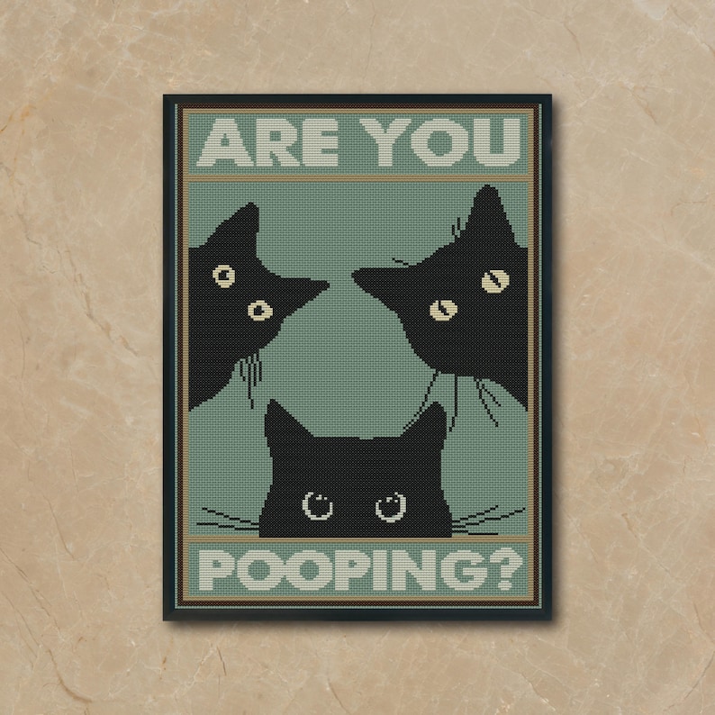 May include: A framed cross-stitch wall art piece featuring three black cat silhouettes on a sage green background. The text ARE YOU is printed in white at the top, and the text POOPING? is printed in white at the bottom, framed in a black border.