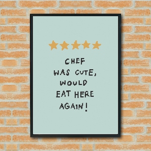 May include: Framed artwork with a light blue background and the text "CHEF WAS CUTE, WOULD EAT HERE AGAIN!" above four gold stars. The artwork is in a black frame and hangs on a brick wall.
