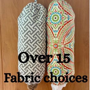 May include: Two cylindrical fabric bag dispensers with hanging loops. The left bag features a grey and white geometric pattern. The right bag displays a colorful mandala-style print in red, green, and blue. Text reads: Over 15 Fabric choices.