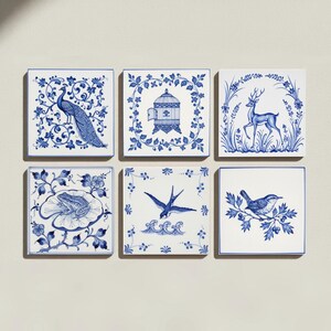 May include: A set of six square ceramic tiles featuring blue and white illustrations. The designs include a peacock, an ornate birdcage, a deer in a forest, a frog on a lily pad, a swallow flying over waves, and a small bird perched on a branch.