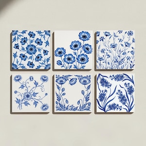 May include: A set of six square ceramic tiles featuring blue and white floral patterns. Each tile displays a distinct botanical illustration, including anemones, cornflowers, and hyacinths, rendered in a classic blue ink style on a white background.