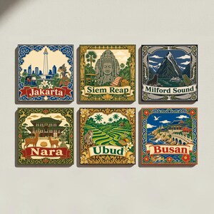 Può includere: Un set di sei piastrelle decorative quadrate con illustrazioni colorate di monumenti e città del mondo. Le piastrelle riportano i nomi Jakarta, Siem Reap, Milford Sound, Nara, Ubud e Busan, ciascuna incorniciata da bordi decorati.