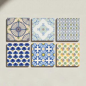 May include: A set of six square ceramic tiles arranged in two rows of three. Each tile features a distinct geometric pattern in shades of blue, green, yellow, and cream. The designs include repeating floral, shell-like, and star-shaped motifs.