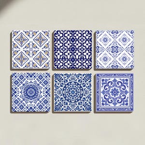 May include: A set of six square ceramic tiles arranged in two rows of three. Each tile features a distinct blue and white pattern, with one tile incorporating yellow accents. The designs include intricate floral, geometric, and symmetrical motifs.
