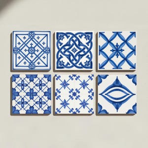 May include: A set of six square ceramic tiles arranged in two rows of three. Each tile features a distinct white background with intricate blue geometric patterns, including interlacing lines, floral motifs, and symmetrical diamond shapes.