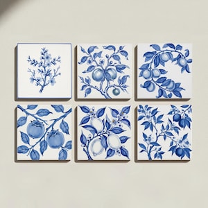 Op de afbeelding: Een set van zes vierkante keramische tegels gerangschikt in twee rijen. Elke witte tegel is voorzien van een gedetailleerde blauwe botanische illustratie, waaronder bloeiende takken, diverse vruchten zoals citroenen en kaki's, en bebladerde stengels.