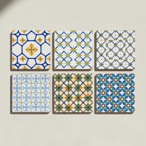 May include: A set of six square ceramic tiles arranged in two rows of three. Each tile features a distinct geometric pattern in shades of blue, yellow, green, and white. The designs include floral motifs, intersecting lines, and star-like shapes.