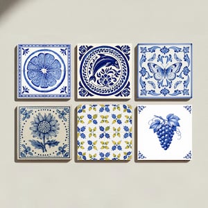 Op de afbeelding: Een set van zes vierkante keramische tegels met blauw-witte ontwerpen. De patronen bevatten een citrusvruchtschijf, een dolfijn, een vlinder, een zonnebloem, een herhalend bloemmotief met gele accenten en een tros druiven op een witte achtergrond.