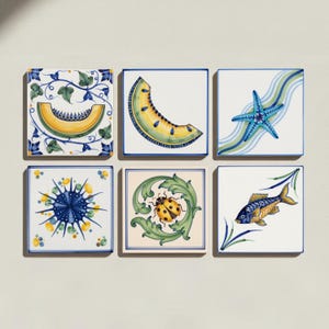 May include: A set of six square ceramic tiles featuring hand-painted designs. The tiles display a yellow melon slice with vines, a yellow melon wedge, a blue starfish, a blue sea urchin, a ladybug on green leaves, and a blue and yellow fish.