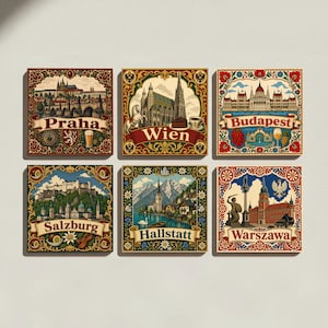 May include: A set of six square decorative tiles featuring colourful illustrations of European cities including Praha, Wien, Budapest, Salzburg, Hallstatt, and Warszawa. Each tile displays a landmark, ornate floral borders, and the city name in a banner.