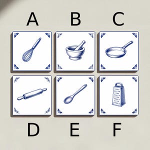 May include: Six square tiles with blue and white illustrations of kitchen tools. The tiles feature a whisk, mortar and pestle, frying pan, rolling pin, spoon, and grater. Each tile has a decorative blue floral border.
