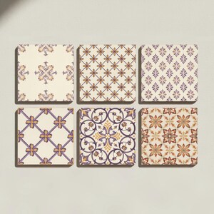 Puede incluir: Un conjunto de seis azulejos cuadrados dispuestos en dos filas de tres. Cada azulejo presenta un patrón repetitivo distinto en tonos morado, dorado y crema. Los diseños incluyen motivos florales, cuadrículas geométricas y volutas.