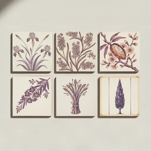 Könnte beinhalten: Ein Set aus sechs quadratischen Fliesen mit botanischen Illustrationen in Lila- und Brauntönen auf cremefarbenem Grund. Die Motive zeigen Schwertlilien, Hyazinthen, eine Kakaofrucht, einen blühenden Zweig, einen Spargelbund und eine einzelne Zypresse.