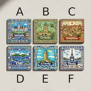 May include: Six square magnets featuring illustrations of European cities. The magnets display the names Santander, Oviedo, Pamplona, Vigo, A Coruña, and Paris. Each design showcases local landmarks, buildings, and decorative borders in a colourful style.