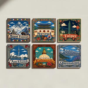 May include: A set of six square decorative wall art prints featuring colorful illustrations of Mount Everest, Seoul, Taipei, Auckland, Kathmandu, and Queenstown. Each print includes the city or landmark name in a banner with ornate borders.