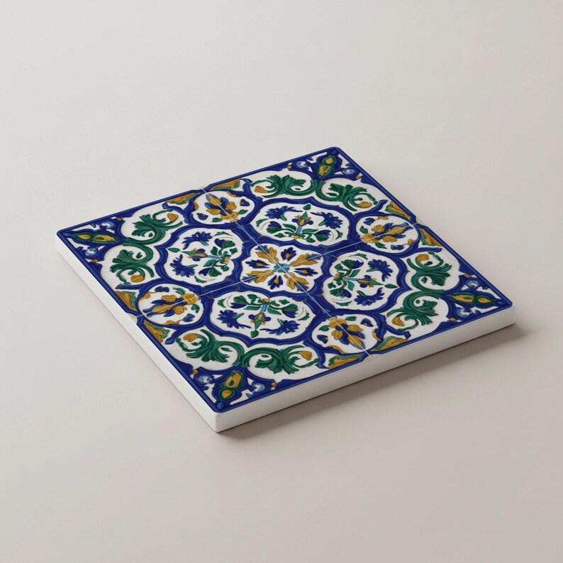 K&ouml;nnte beinhalten: Quadratische Keramikfliese mit einem sich wiederholenden Blumenmuster in Blau, Gr&uuml;n, Gelb und Wei&szlig;. Die Fliese hat einen wei&szlig;en Rand und ein detailliertes, symmetrisches Design, ideal f&uuml;r Heimdekoration oder Bastelprojekte.