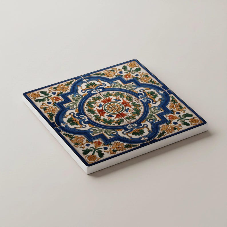 K&ouml;nnte beinhalten: Quadratische Keramikfliese mit detailliertem Blumendesign in Blau, Orange, Gr&uuml;n und Rot. Die Fliese hat einen wei&szlig;en Rand und ein zentrales kreisf&ouml;rmiges Muster. Dekorative Fliese f&uuml;r die Inneneinrichtung.