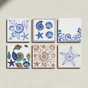 May include: A set of six square ceramic tiles featuring various marine life illustrations. Three tiles display blue and white patterns of seashells, starfish, and coral, while the others incorporate shades of brown, teal, and blue in their designs.