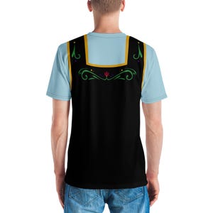 Pu&ograve; includere: Una maglietta nera e blu con un design floreale stilizzato sul retro. Il design presenta un fiore rosso, foglie verdi e accenti dorati.