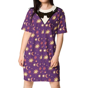 May include: A purple t-shirt dress with a black bow tie and a pattern of gold stars and crescent moons.
