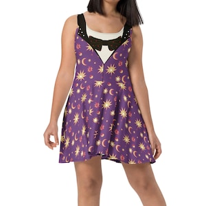 May include: Purple skater dress with a celestial print of stars and moons. The dress has a black and white bow tie and a white collar.