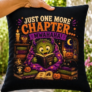 May include: A black square throw pillow featuring a colorful graphic of a green monster reading a book titled Spooky Stories. The text reads Just One More Chapter Mwahaha. The design includes pumpkins, candles, books, and a black cat.