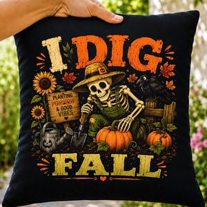 May include: A black square throw pillow featuring a graphic of a skeleton wearing a straw hat and green overalls, gardening with a shovel and pumpkins. The text reads I DIG FALL and PLANTING PUMPKINS & GOOD VIBES, surrounded by sunflowers and a crow.
