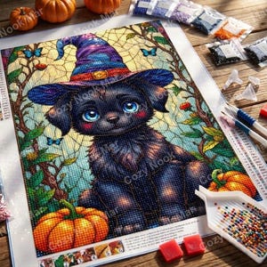 May include: A diamond painting kit featuring a black puppy wearing a purple and blue witch hat, surrounded by orange pumpkins, green leaves, and blue butterflies. The kit includes a printed canvas, small bags of colored resin drills, a tray, and tools.
