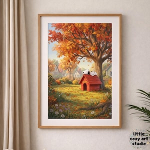 May include: Framed art print featuring Snoopy sleeping on his red doghouse under a large tree with autumn foliage. The artwork has a warm color palette of orange, yellow, and green, with a blue sky and houses in the background. The print is in a wooden frame.