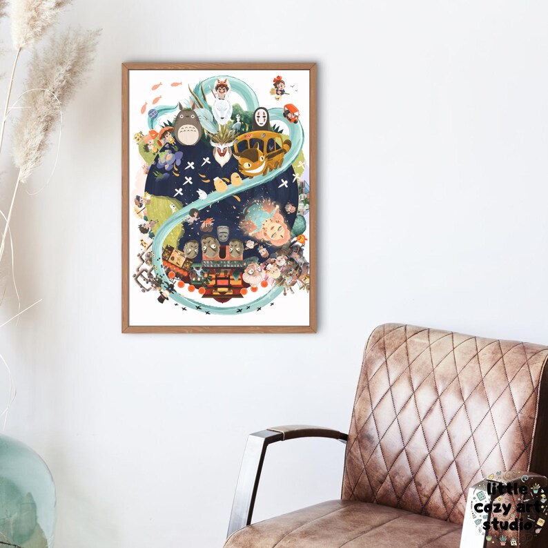 Op de afbeelding: Een ingelijste kunstdruk met een kleurrijke illustratie van verschillende animatiefiguren. Het kunstwerk bevat een groot, harig wezen, een gele bus en andere grillige figuren. De print zit in een houten lijst en hangt aan een witte muur.
