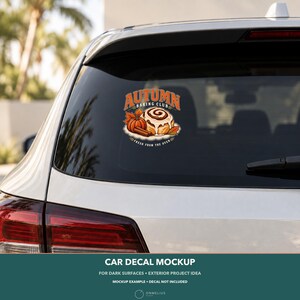May include: A circular car decal featuring a cinnamon roll, a pumpkin, and cinnamon sticks. The text reads AUTUMN BAKING CLUB and FRESH FROM THE OVEN. The design includes orange and brown autumn leaves on a white background, applied to a car window.