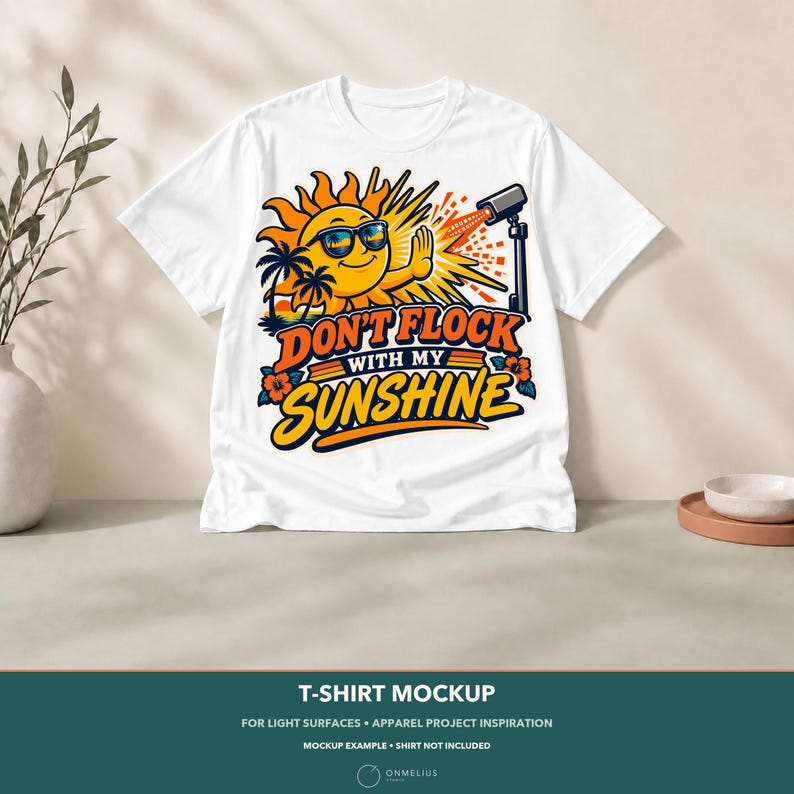 May include: A white t-shirt featuring a graphic of a smiling sun wearing sunglasses, palm trees, and a security camera. The text reads DON'T FLOCK WITH MY SUNSHINE in bold orange and blue letters, accented with orange hibiscus flowers.