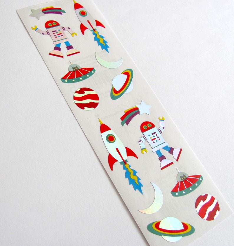 May include: A sheet of colorful space-themed stickers featuring robots, rockets, planets, stars, and UFOs. The stickers are perfect for adding a fun and whimsical touch to any project.