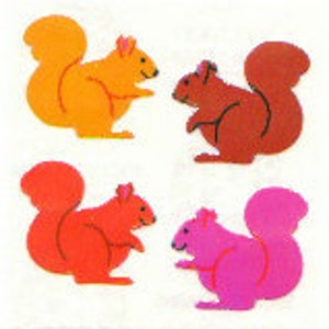 Puede incluir: Cuatro formas de ardilla de fieltro en naranja, marrón, rojo y rosa. Las ardillas están todas mirando hacia el lado derecho de la imagen y tienen las colas enroscadas detrás de ellas.