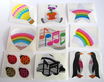 Puede incluir: Una hoja de pegatinas coloridas con un globo aerostático, un oso con gafas de sol, una estrella arcoíris, un corazón con un arcoíris, notas musicales, una nube con un arcoíris, mariquitas, un diseño de nota musical y pingüinos.