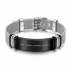 May include: A silver-tone mesh bracelet featuring a black rectangular centre plate with a white Morse code pattern. The bracelet includes a silver-tone buckle closure and two silver and black decorative accents on each side of the centre plate.