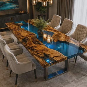 May include: A rectangular dining table featuring a live edge wood slab with a central translucent blue resin river inlay, supported by a dark metal frame. Eight upholstered beige chairs with dark legs are arranged around the table.