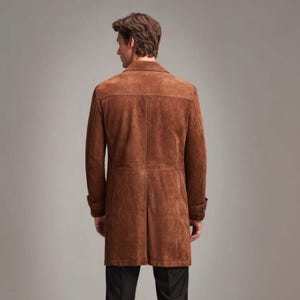 May include: A brown suede coat with a classic design. The coat features a notched collar, buttoned cuffs, and a tailored fit. The coat is approximately 40 inches long.