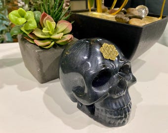 Donkergrijszwarte harsschedel met gouden Flower of Life-symbool