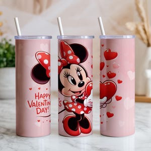 Op de afbeelding: Drie roze ge&iuml;soleerde bekers met witte rietjes. E&eacute;n beker toont Minnie Mouse met een hart, een andere zegt "Happy Valentine's Day!" met harten, en de derde heeft zwevende harten. De bekers zijn voor Valentijnsdag.