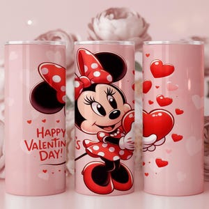 Op de afbeelding: Roze ge&iuml;soleerde beker met Minnie Mouse in een rode polkadotjurk en strik, met een hart. De beker heeft de tekst "Happy Valentine's Day!" en hartafbeeldingen. Bloemenachtergrond.