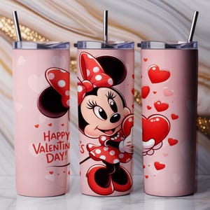Op de afbeelding: Drie roze ge&iuml;soleerde bekers met zilveren rietjes. E&eacute;n beker heeft Minnie Mouse met een hart, een andere heeft een Minnie Mouse-strik en de derde heeft zwevende harten. De woorden "Happy Valentine's Day!" staan op &eacute;&eacute;n beker.