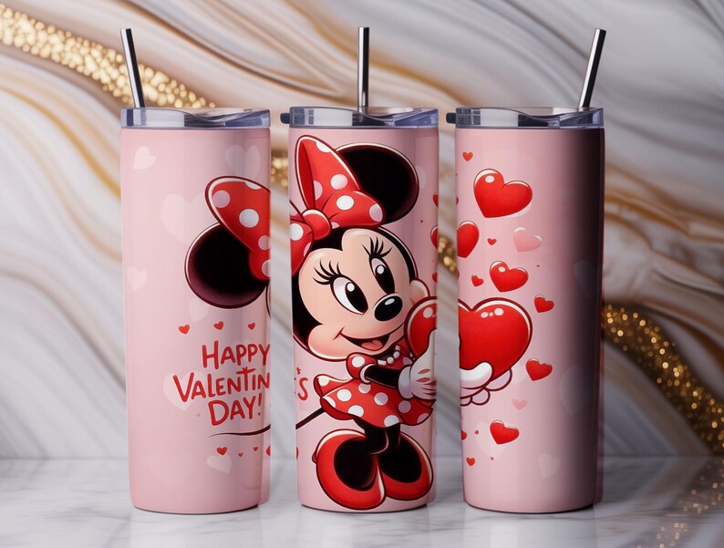 Op de afbeelding: Drie roze ge&iuml;soleerde bekers met zilveren rietjes. E&eacute;n beker heeft Minnie Mouse met een hart, een andere heeft een Minnie Mouse-strik en de derde heeft zwevende harten. De woorden "Happy Valentine's Day!" staan op &eacute;&eacute;n beker.