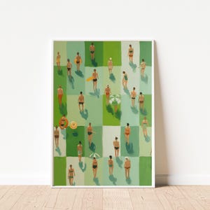 May include: A framed art print featuring an aerial view of a beach scene. The artwork depicts numerous figures in swimwear and swim trunks, interspersed across a green and white checkered background. A beach umbrella and floatation devices are also visible.