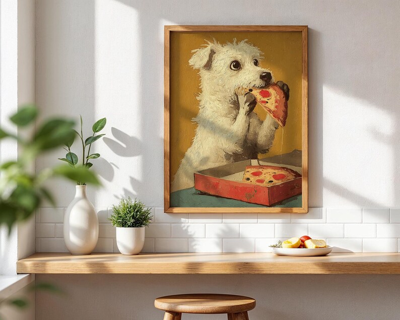 May include: A framed print shows a white dog enjoying a slice of pizza from a red box. The dog has a surprised expression. The background is yellow, and the print is in a wooden frame. The image is on a white wall, above a wooden shelf.