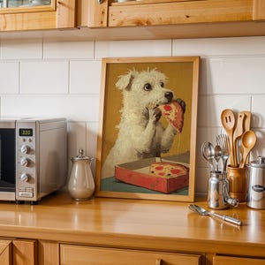 May include: A framed print of a white dog eating pizza, displayed on a wooden countertop. A stainless steel microwave, a small silver container, and kitchen utensils are also visible.
