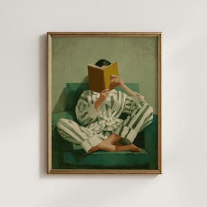 May include: A framed painting in a vintage style shows a person in striped pyjamas reading a book while seated on a teal armchair. The book is yellow, and the background is a muted green.