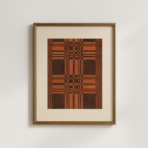 May include: Framed artwork featuring a geometric plaid pattern in shades of brown and orange. The artwork is displayed in a gold-colored frame with a cream-colored mat. The plaid design is composed of intersecting horizontal and vertical lines.